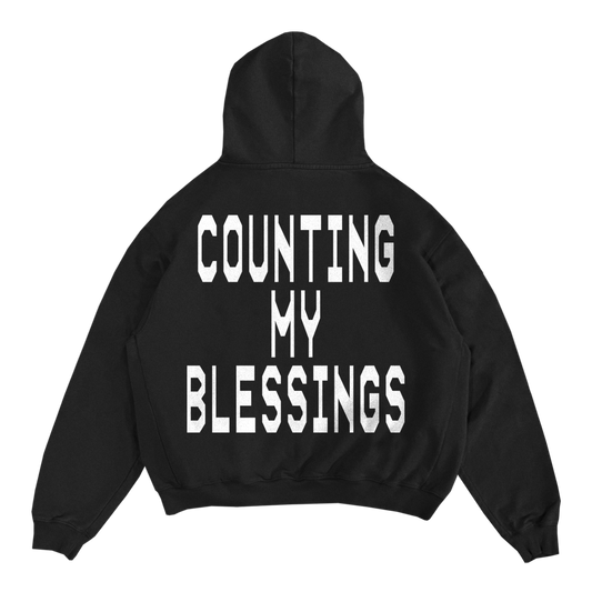 Black hoodie with large, white text that says 'COUNTING MY BLESSINGS'.